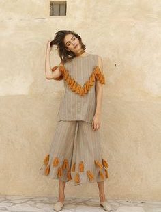 Pom pom adorned knit bombers, wool shag espadrilles and tassel trimmed everything?! Mochi designer Ayah Tabari, once again, is speaking my language with her spring collection. This season, the Palestinian designer has moved on from the motifs of Uzbekistan and onto the warm desert hues and pops of