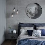 a chic grey and navy bedding set plus a blue rug enliven the grey bedroom