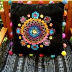 crocheted embellishments on cushion cover - pom-poms too!