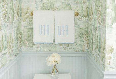 Bathroom with blue wainscoting and green scenic Sanderson wallpaper and monogrammed Weezie towels by Tori Alexander of Alexander Interiors in Nashville.