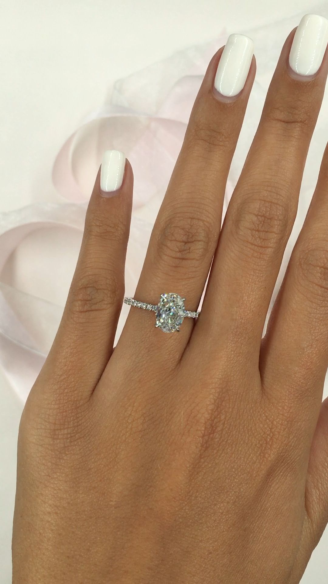 Oval shaped diamond. Side stone pave setting in 14k white gold. Ovals are a cool and beautiful shape for a bride to be
