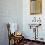 French Country Bathroom in bathroom ideas, white tiled bathroom with checkerboard tiled floor, traditional sink and fittings, antique gold vanity mirror.