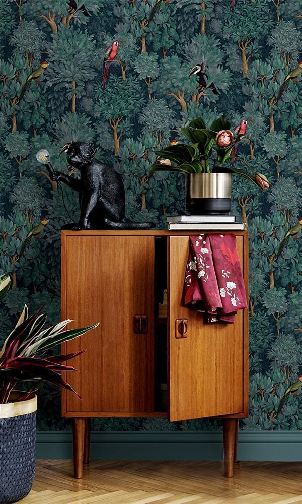 Lush Tropical Foliage Wallpaper This lush tropical wallpaper features a charming seamless pattern of thick jungle trees and foliage climbing the wall, sprinkled with colorful tropical birds throughout. The hand painted style paired with the rich colors and depth make this a playful, lively, and elegant wallpaper for your living room or powder room.