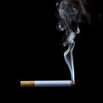 Smoking cigarette on black background Pr...
