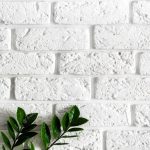 Premium Photo | Green plant branch on white brick wall modern home interior  background, natural leaves on clean texture concrete cement pattern surface brickwork, vertical image with copy space for text