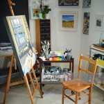 Creative painting artist studio workspace with paints, brushes,...