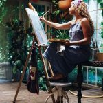 Indoor shot of professional female artist painting on canvas in studio with plants Stock Photo - Alamy
