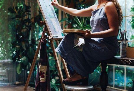 Indoor shot of professional female artist painting on canvas in studio with plants Stock Photo - Alamy
