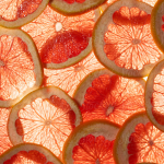 "Pomelo Or Grapefruit Slice Background" by Stocksy Contributor "Juno"